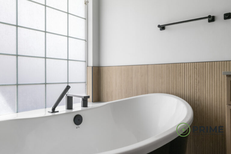 Austin bathroom remodeling contractor showcasing a modern Austin bathroom with freestanding tub, black fixtures, and light wood accents