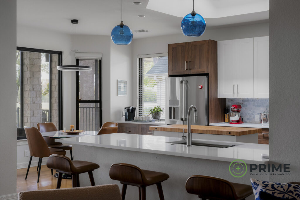 Austin TX kitchen remodeling showcasing an Austin kitchen remodel with white island, wood cabinets, stainless appliances, and large windows