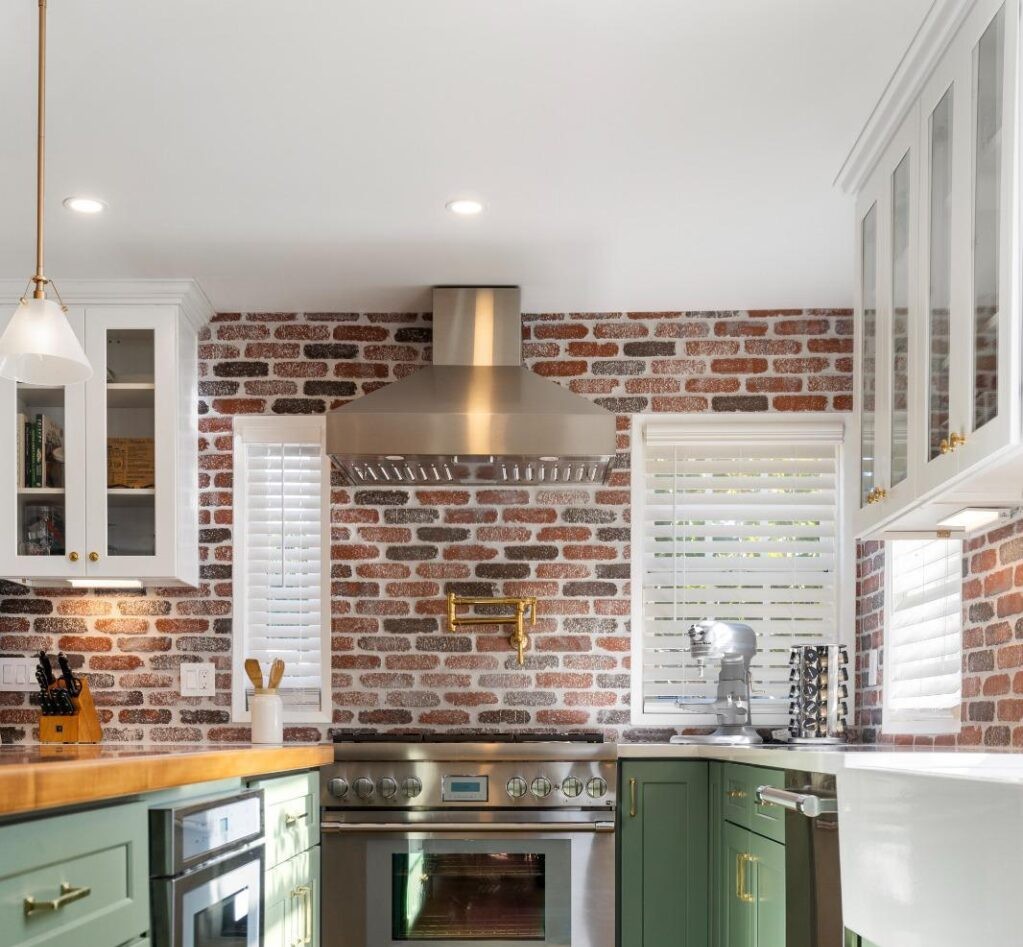 Kitchen remodeling company austin showcasing exposed brick walls, green custom cabinets, and butcher block countertops in a stylish Austin kitchen remodel