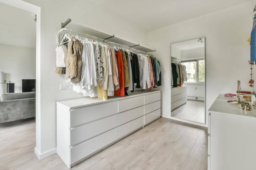 Residential remodeling services austin tx featuring a modern walk-in closet with custom built-ins, light wood floors, and seamless transition to the living room