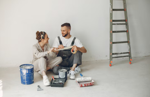 Austin home remodeling contractors assisting a smiling couple prepping a wall for painting during an Austin home renovation project