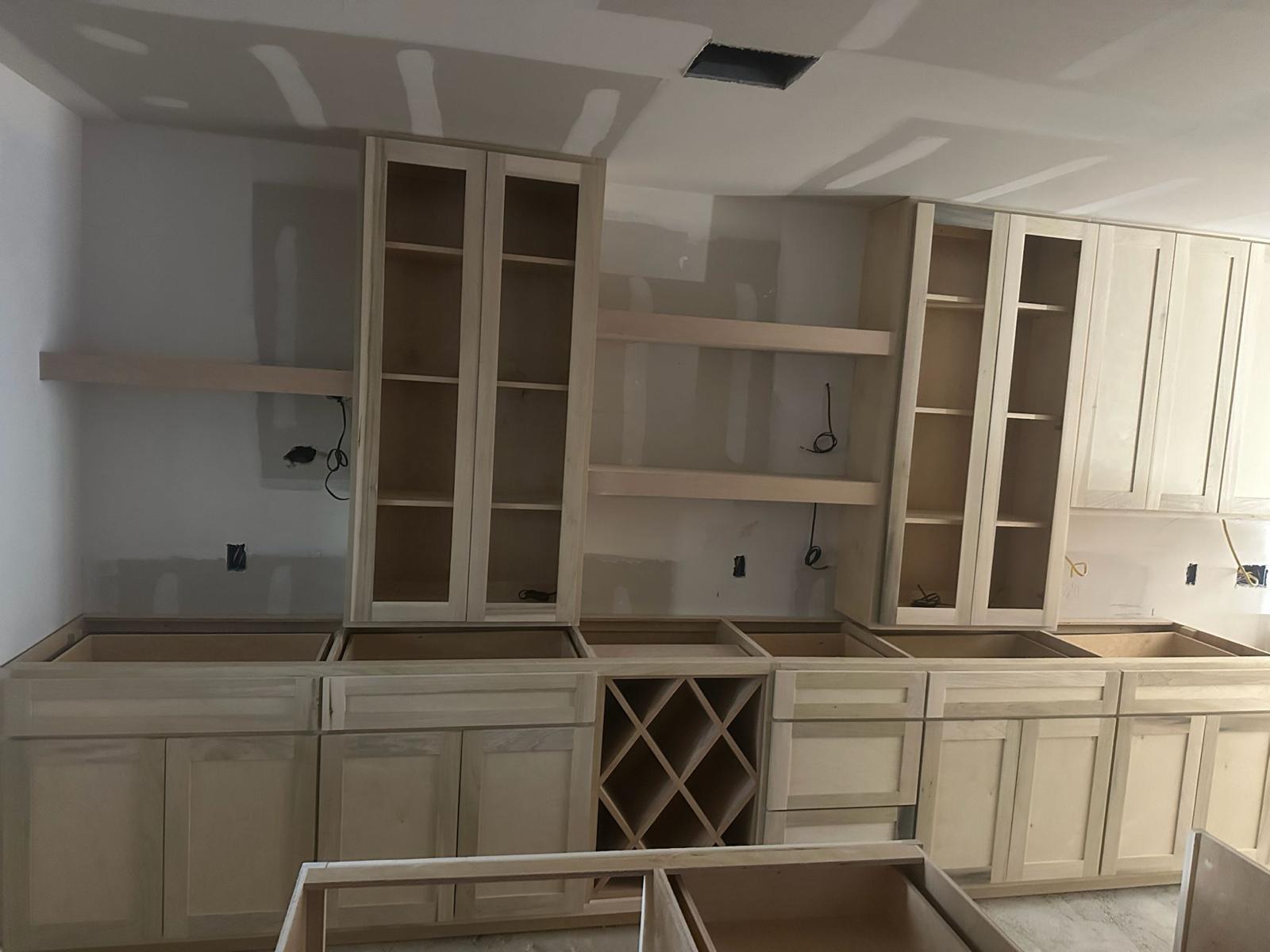 Kitchen remodeling company Austin showcasing Austin kitchen remodel with unfinished cabinets, open shelving, and exposed drywall