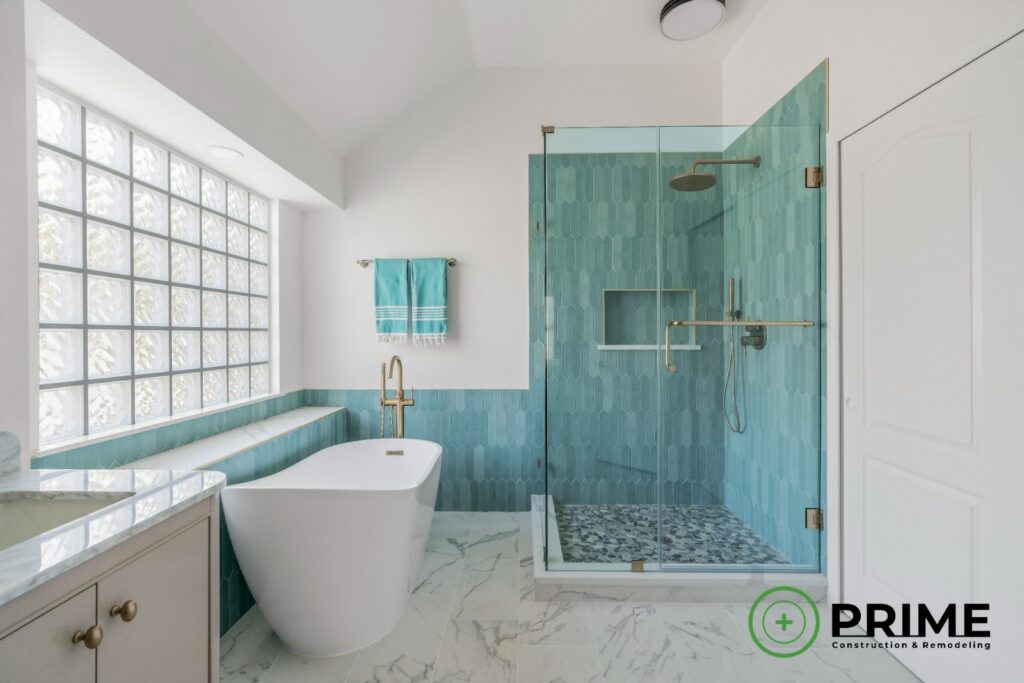 Bathroom remodeling Austin TX master bathroom remodel in Austin featuring a freestanding tub, glass shower enclosure, teal tile walls, and modern brass fixtures