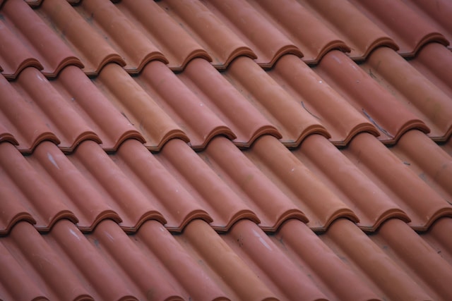 Roofing Austin showcasing a reddish-brown clay tile roof neatly arranged for home renovation projects