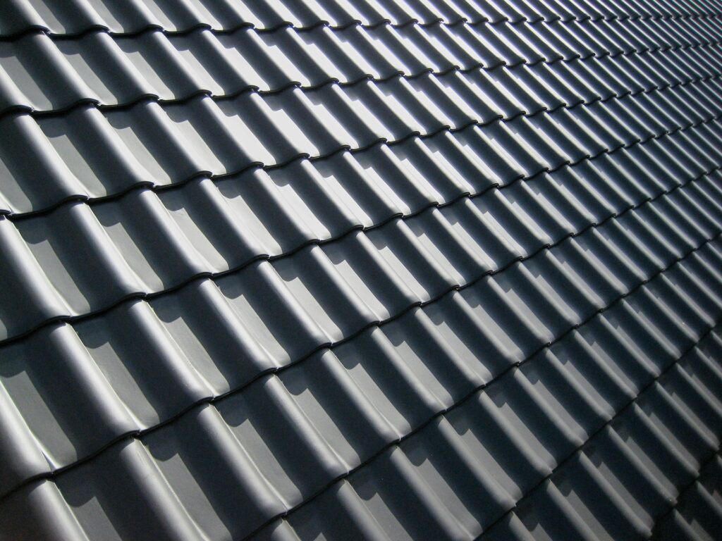 Roofing Austin showcasing dark gray wavy roof tiles arranged in neat rows, inspiring modern home renovation